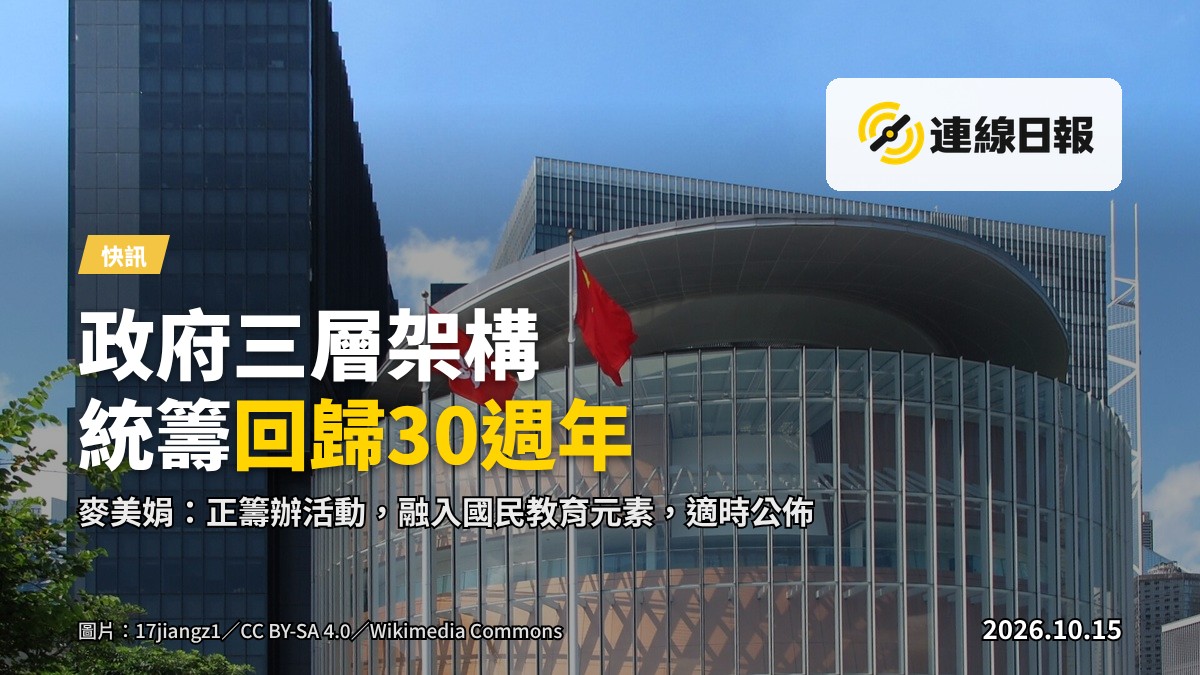 香港立法會會議廳的陳設：長形會議桌配議席，前方為主席台及國徽式樣背景，無人，光線明亮。