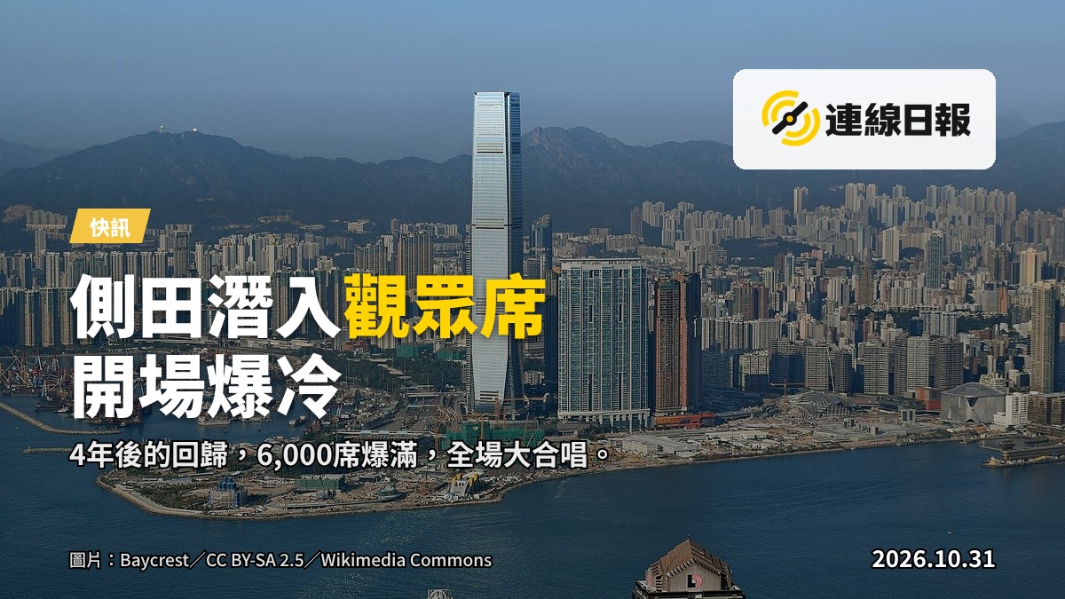 西九文化區海旁户外音樂會，數千名觀眾在舞台前揮動螢光棒，背景為竹翠公園綠地，夜色燈籠輝映