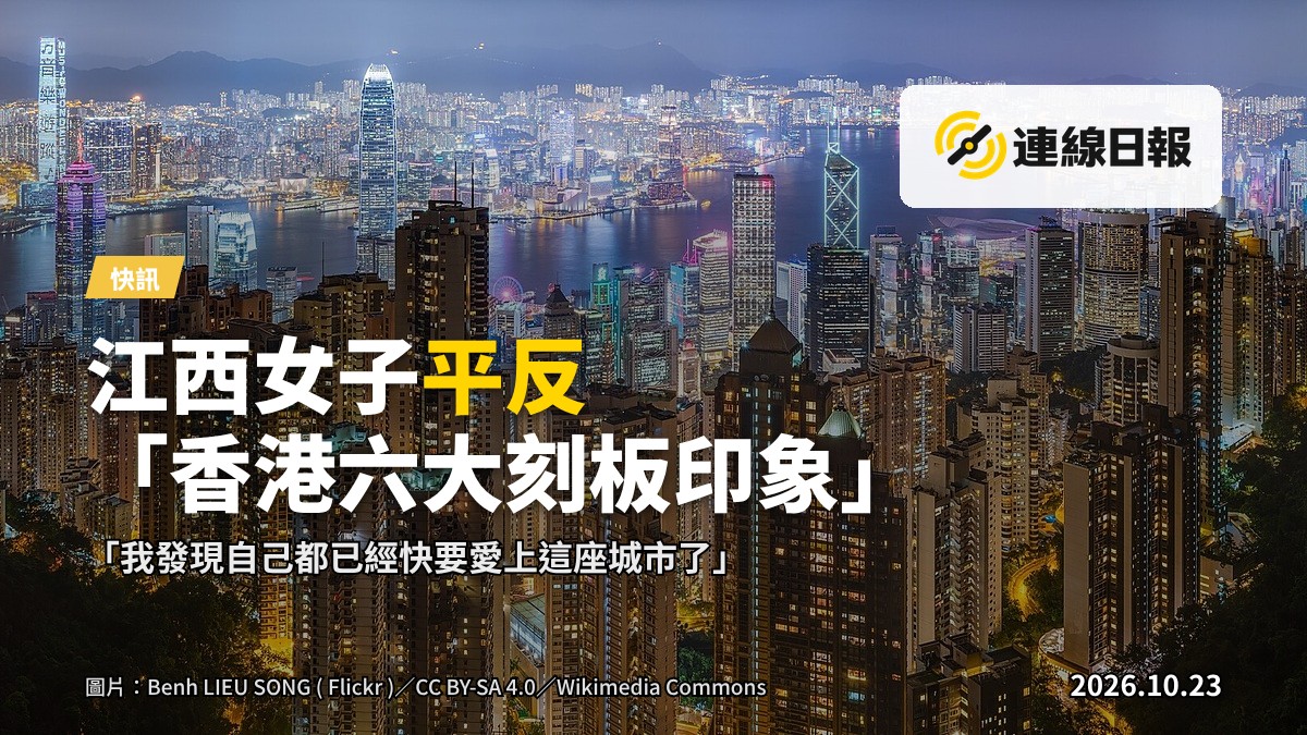 一名旅客手持電話站在便利店外，對面是香港市中心的高樓天際線（不顯示面部）。
