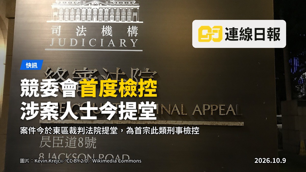 香港司法機構旗幟懸掛於法院大樓入口上方，前景為石級通道。本案為首宗涉及向競委會提供虛假資料的刑事檢控，案件今日在東區裁判法院提堂。
