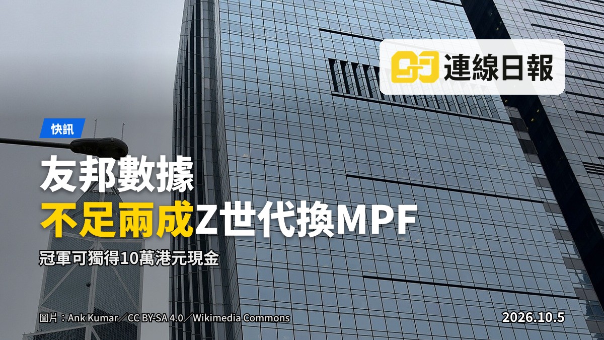 一名年輕僱員背對鏡頭，在辦公室內使用手提電腦檢視投資組合，窗外為都市天際線。